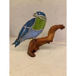 Petit oiseau en verre sur une branche